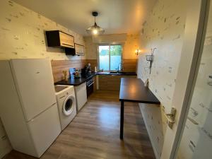 a kitchen with a washer and dryer next to a refrigerator at Le Lodge d Angèle in Honfleur +2 photos