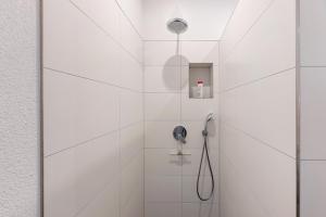 a bathroom with a shower with white tiles at Studio im Grünen und Bodenseenähe in Rielasingen-Worblingen +16 photos
