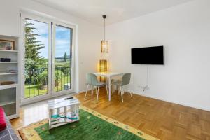 a living room with a table and a tv at Studio im Grünen und Bodenseenähe in Rielasingen-Worblingen