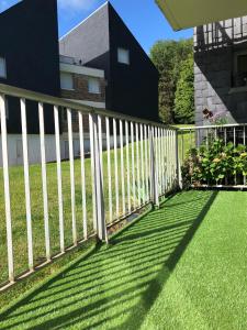 a white picket fence in front of a yard at Le Lodge d Angèle in Honfleur