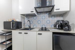 a kitchen with white cabinets and a sink at Casa Luna in Pozzallo +12 photos