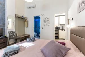 a bedroom with a large bed and a kitchen at Casa Luna in Pozzallo