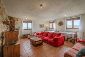 a living room with a red couch and a table at La Alameda in Marazuela