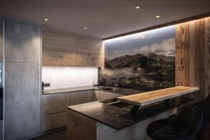 a kitchen with a table and a painting on the wall at Rueper Hof Chalet Dolomit in Valdaora