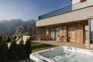 a hot tub on the patio of a house at Rueper Hof Chalet Dolomit in Valdaora