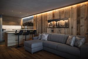 a living room with a couch and a bar at Rueper Hof Chalet Dolomit in Valdaora