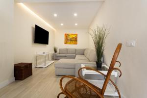 a living room with a couch and a tv at Mojo Surf Yoga House in La Orotava
