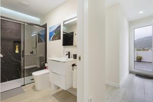 a white bathroom with a toilet and a shower at Mojo Surf Yoga House in La Orotava +33 photos
