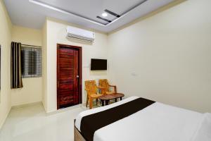 a bedroom with a bed and a table and chairs at Super HOTEL O GOLDEN CITY INN in Maula Ali +23 photos