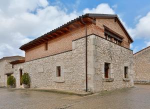 a large brick building with a roof at El Lagar in Canalejas de Peñafiel