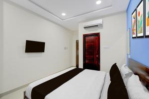 a bedroom with a white bed and a television at Super HOTEL O GOLDEN CITY INN in Maula Ali