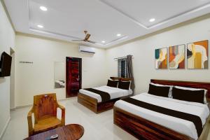 a hotel room with two beds and a chair at Super HOTEL O GOLDEN CITY INN in Maula Ali