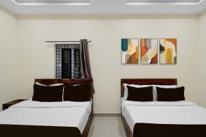 two beds sitting next to each other in a room at Super HOTEL O GOLDEN CITY INN in Maula Ali