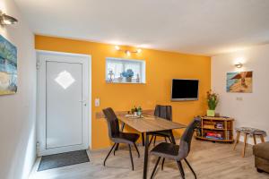 a dining room with a table and chairs and a tv at Ferienwohnung Helms in Eriskirch
