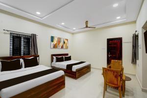 a bedroom with two beds and a chair at Super HOTEL O GOLDEN CITY INN in Maula Ali