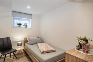 a room with a couch and a chair and a window at Ferienwohnung Helms in Eriskirch