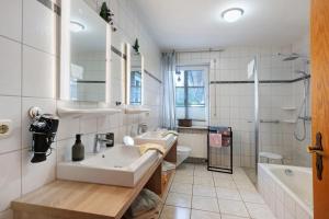 a bathroom with a sink and a toilet and a tub at Haus Deichgraf in Nordstrand +147 photos