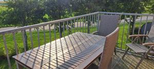 a wooden bench and two chairs on a balcony at Fewo Sandbank in Pellworm