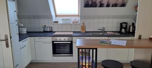 a kitchen with white cabinets and a counter top at Fewo Sandbank in Pellworm