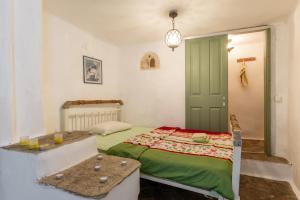 a bedroom with a bed and a green door at Haus Nikos - Tinos - Arnados in Arnados