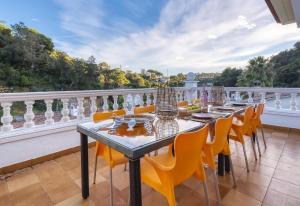 a row of tables on a balcony with yellow chairs at Costacabana - Villa Rosa in Lloret de Mar