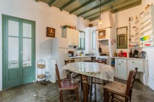 a kitchen with a table and chairs in a room at Haus Nikos - Tinos - Arnados in Arnados