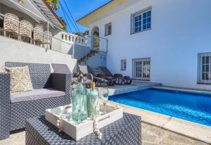 a backyard with a swimming pool and a villa at Costacabana - Villa Rosa in Lloret de Mar
