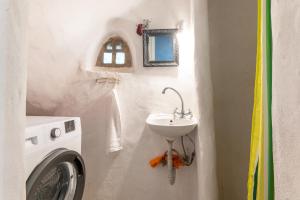 a bathroom with a sink and a washing machine at Haus Nikos - Tinos - Arnados in Arnados