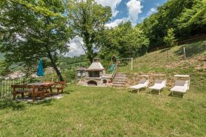 a backyard with a table and chairs and a fireplace at Nonno Bigi Tulipano in Tremosine Sul Garda