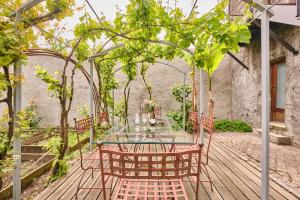 a table and chairs on a wooden deck with trees at Chateau De Merande in Arbin