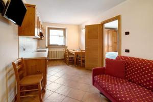 a living room with a couch and a kitchen with a table at Chalet Anna Cigambola in Livigno