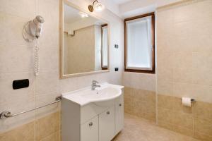 a bathroom with a sink and a mirror at Chalet Anna Cigambola in Livigno