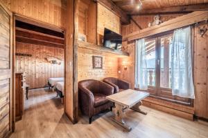 a room with a couch and a table and a bed at Gand chalet montagne 30 personnes in Bernex