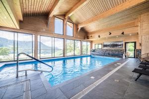 a large indoor swimming pool in a building with windows at Gand chalet montagne 30 personnes in Bernex