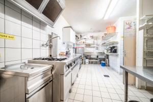 a large kitchen with white tile floors and appliances at Gand chalet montagne 30 personnes in Bernex