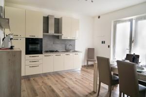 a kitchen with white cabinets and a dining table at appartamento casa stefi n2 in Malcesine