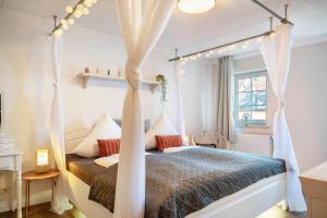 a bedroom with a canopy bed and a window at Die Residenz in Neidenbach