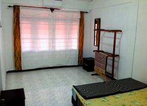 Habitación con ventana y cama. en Nur Muslim Homestay At Kota Bharu en Kota Bharu