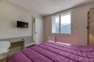 a bedroom with a purple bed and a window at Logis Les Forges in Arvillard