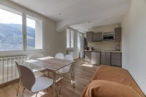 a kitchen and dining room with a table and chairs at Logis Les Forges in Arvillard