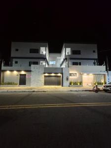a building on the side of a street at night at Praia Do Morro Suites Para Grupos Guarapari-es in Guarapari