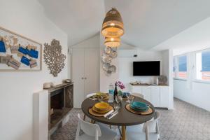 a dining room with a table and chairs and a television at Casa Royale Appartamento Aria in Lierna