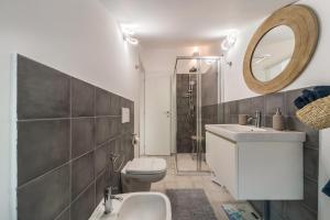 a bathroom with a sink and a toilet and a mirror at Casa Royale Appartamento Aria in Lierna +18 photos