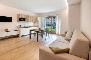 a living room with a couch and a kitchen with a table at Chalet Ale Livigno in Livigno
