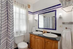 a bathroom with a toilet and a sink and a mirror at La Casa Amarilla in El Paso +16 photos
