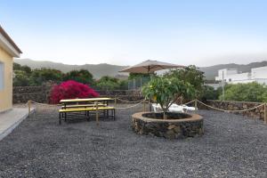 a picnic table and a bench with an umbrella at La Casa Amarilla in El Paso