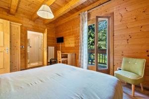 a bedroom with a bed and a chair and a window at Agritur El Casel in Brentonico