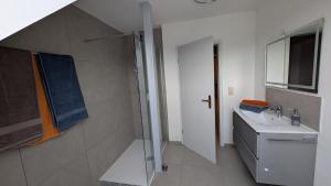 a white bathroom with a sink and a shower at Gerda Ferienwohnung in Weigendorf