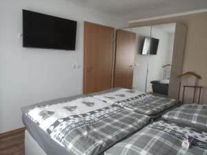 a bedroom with two beds and a flat screen tv at Ferienwohnung Mai, 63qm in Plettenberg