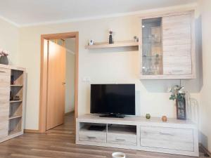 a living room with a flat screen tv on a entertainment center at Ferienwohnung Mai, 63qm in Plettenberg